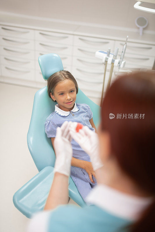 女孩看着她的牙医准备口腔保护装置