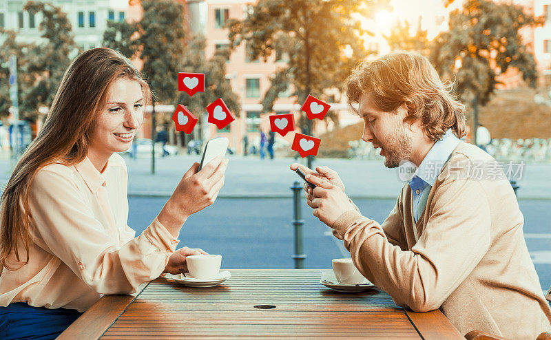 情侣在约会时用智能手机在社交媒体上按按钮
