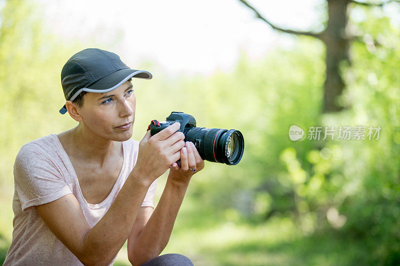 成年女性摄影师看着她的主题