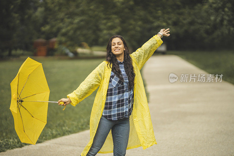 快乐的女人微笑着行走在雨天