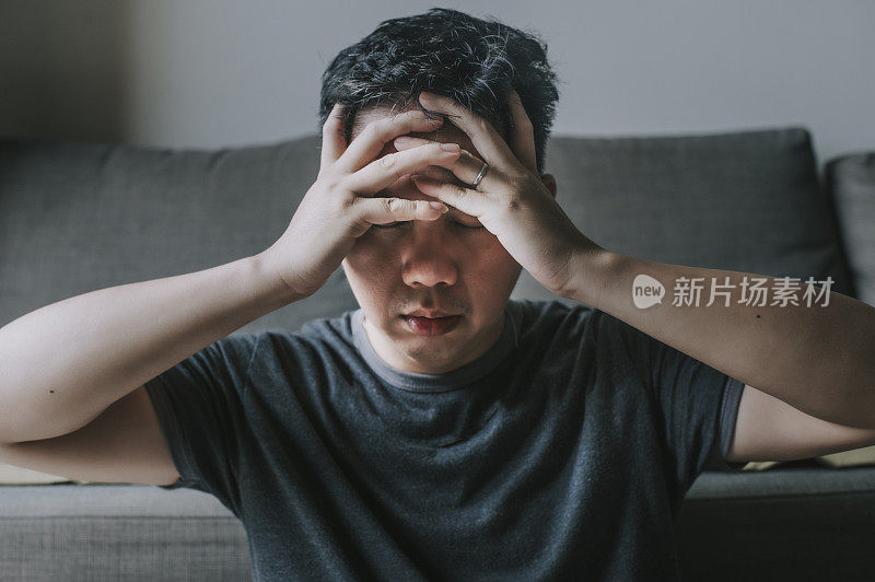 一位亚洲华人中年男子在客厅休息，有流感症状