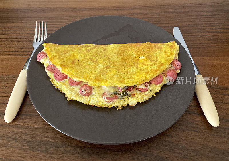 混合炒蛋;美味的煎蛋卷与香肠和混合蔬菜为slide盘子里的健康早餐。