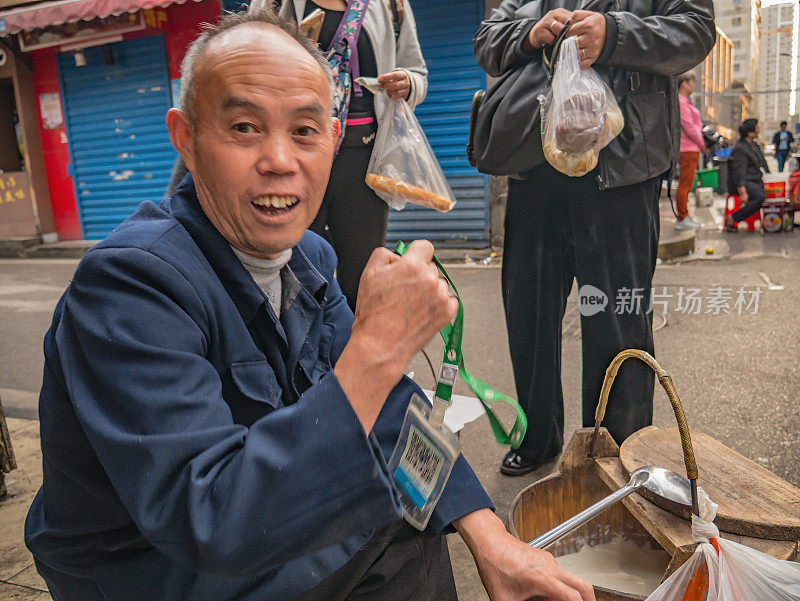 不熟悉的资深人士在街上卖豆腐在中国湖南长沙市的早上。太平老街是长沙市的标志性建筑之一