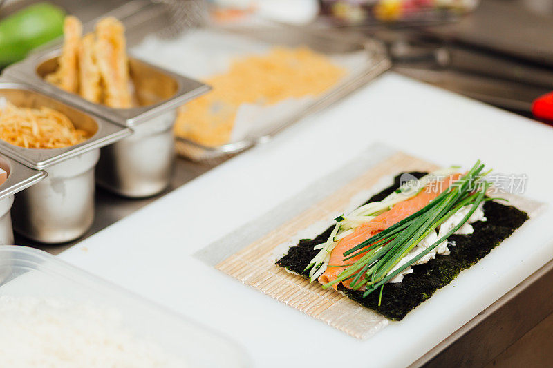 准备,寿司。三文鱼，鳄梨，米饭和筷子餐桌