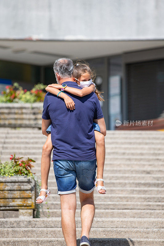 父亲带着有COVID-19症状的女儿前往医院大楼