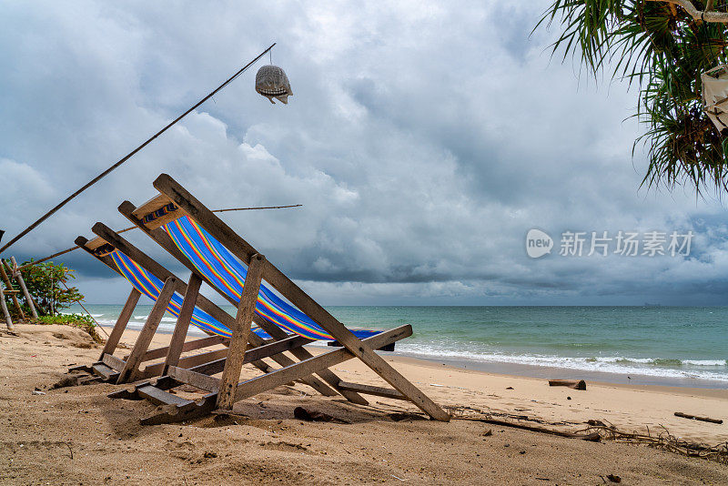 封锁期间，暴风雨肆虐的海滩上的两把空折叠椅