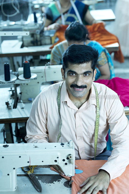 在纺织厂用缝纫机缝制衣服的人