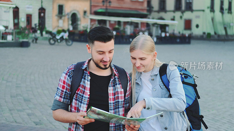 年轻夫妇带着地图在市中心寻找新的历史地点