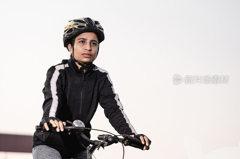 肖像运动女运动员的自行车站在她的自行车。