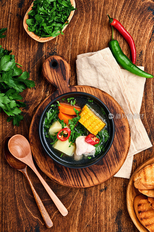 智利肉汤，玉米，新鲜的香菜和土豆放在旧木桌的背景上。做到。Latinamerican食物。