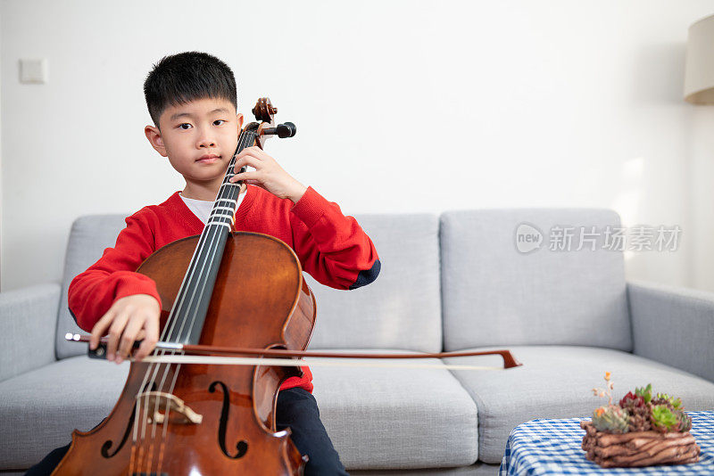小男孩在室内练习大提琴