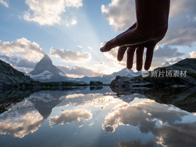 手触阳光的细节，马特洪峰山下的山湖