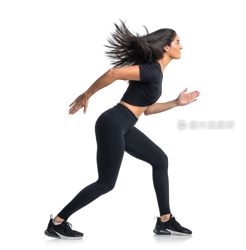 女子短跑运动员穿着黑色在白色背景下奔跑