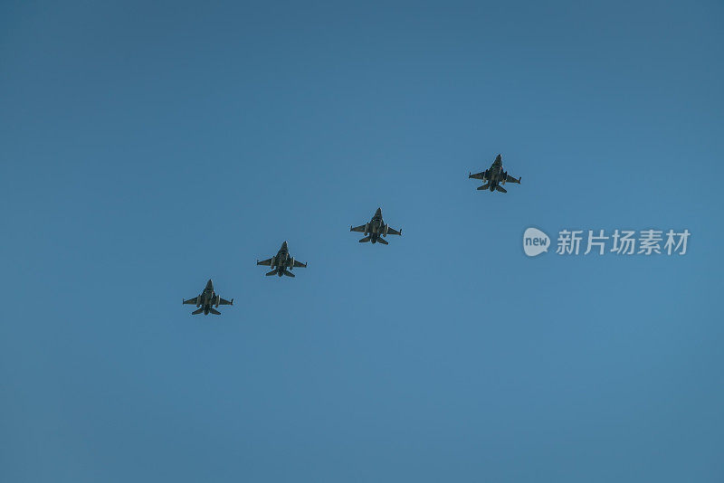 蓝天背景下的四架飞机。在阅兵过程中，一群专业的军用飞机飞行员在空中表演特技