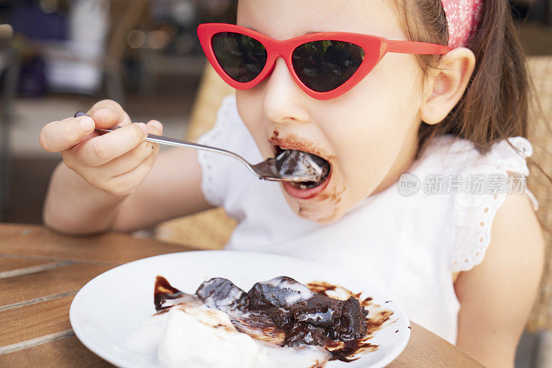 可爱的小女孩在吃巧克力蛋糕