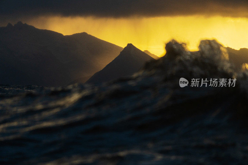 夕阳在波涛汹涌的海面上，带着一艘小船从开阔的大海上驶来