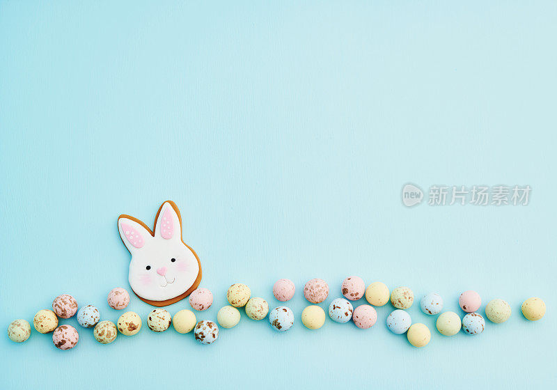 粉彩复活节背景与复活节兔子饼干装饰和粉彩巧克力复活节糖果