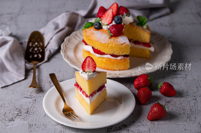维多利亚三明治蛋糕，装饰着草莓，蓝莓和薄荷特写