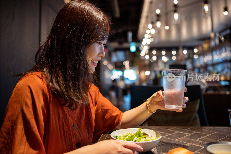 在高档餐厅喝水的女人