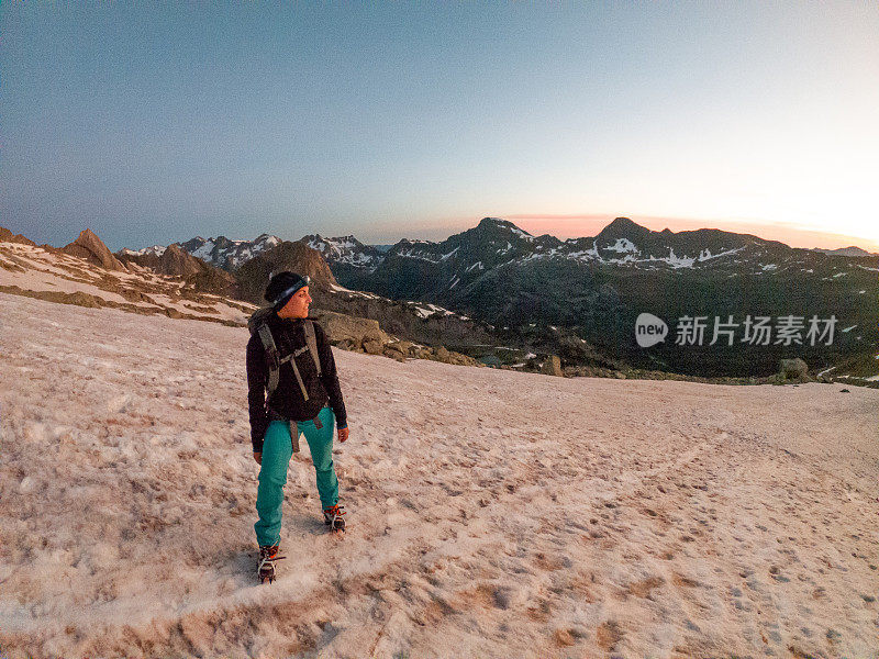 女登山者在雪道上攀登山峰