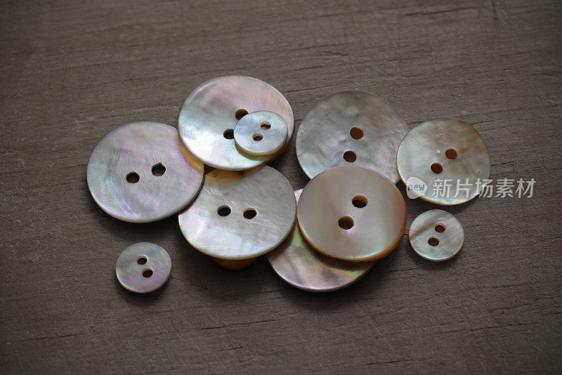 钮扣由天然珍珠母在粗糙的木制背景制成