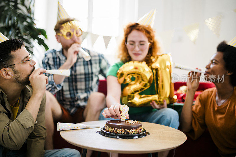 一群年轻人在享受生日聚会，朋友们在生日聚会上玩得很开心