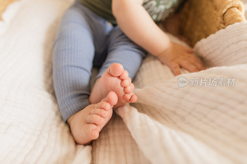 7个月大的男婴，有12个脚趾，躺在一个舒适的海草摩西篮子里，白色亚麻布