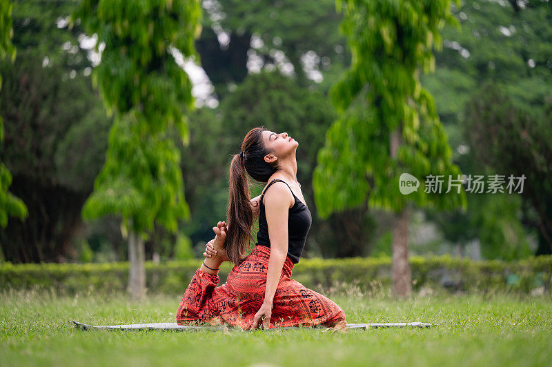 亚洲女子在公园练习瑜伽姿势