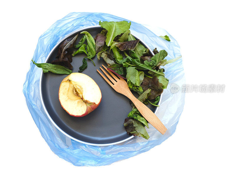 蓝色盘子，食物垃圾在垃圾袋。家里的食物浪费。