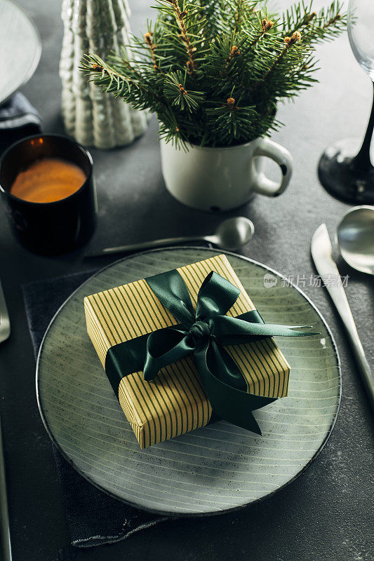 圣诞节或新年餐桌摆设。工艺蓝色盘子餐具和礼品盒，杉树树枝