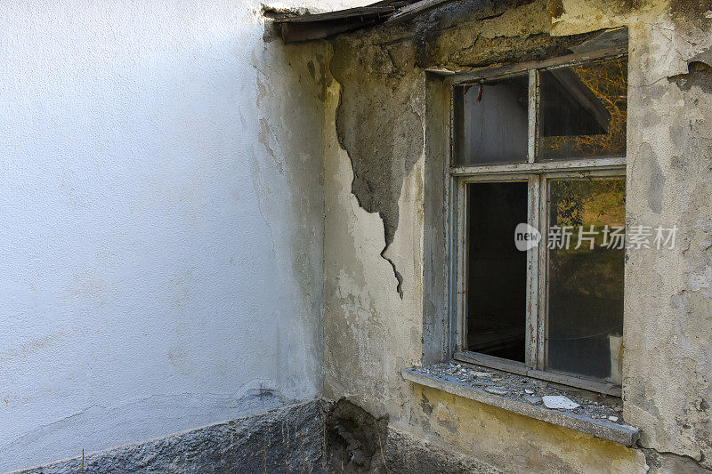 旧而废弃的建筑外观和受损的窗框