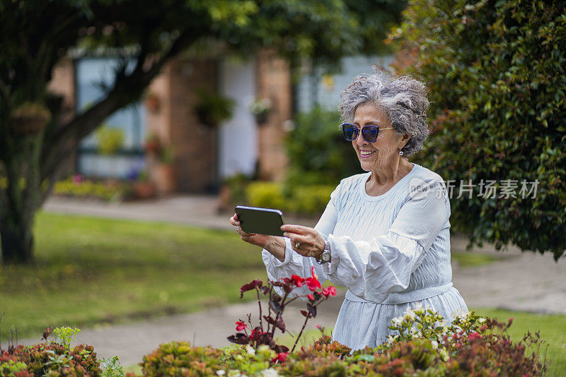退休妇女用她的手机拍照
