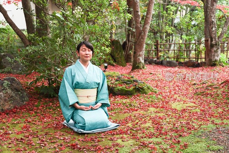 日本女子在传统的日本旅社花园冥想
