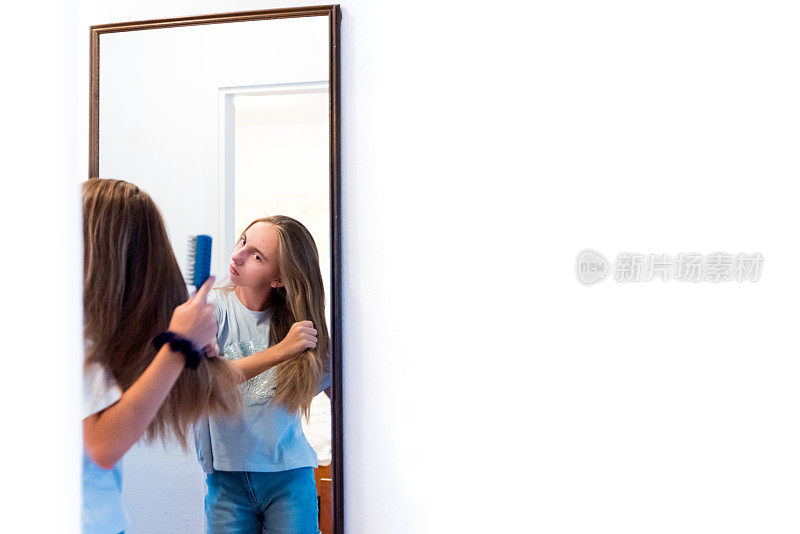 少女在镜子前梳理她的长发