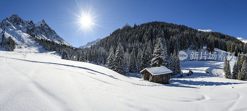 冬天的风景，有一个古老的小屋和雪山