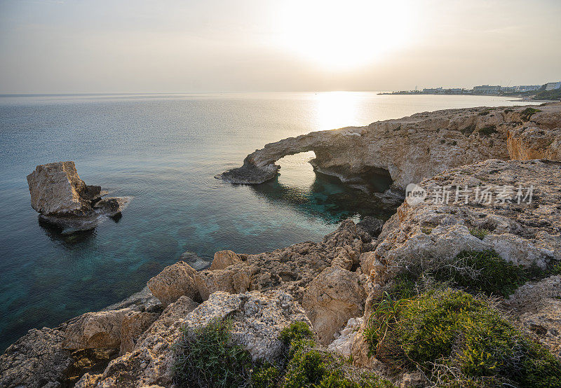 塞浦路斯阿伊亚纳帕附近的天然岩石拱门上美丽的日落。恋人之桥，地中海