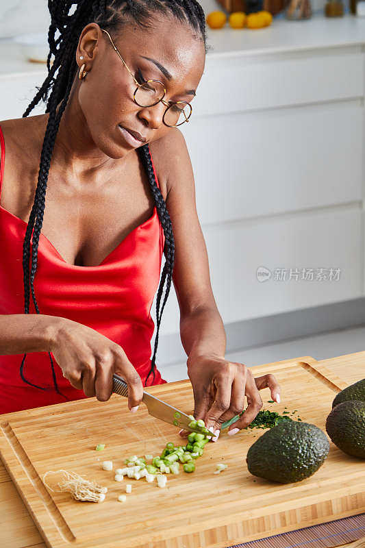 优雅的黑人女孩在厨房准备素食沙拉