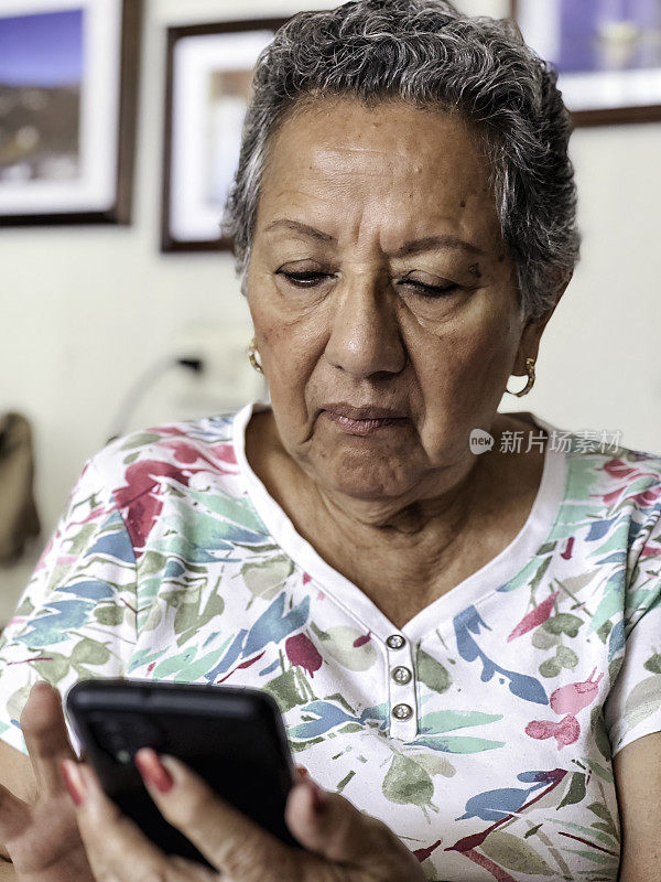 老年妇女在家使用智能手机