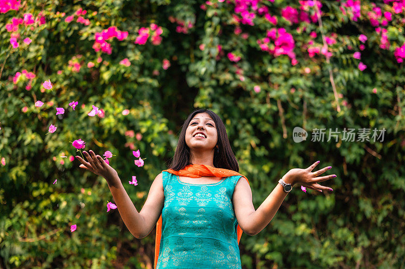 在公园里享受洒花瓣的女人