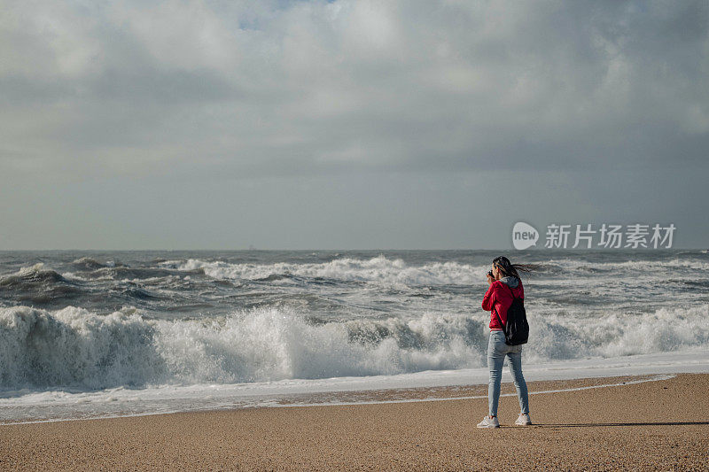一个女人拍了一张海浪的照片。