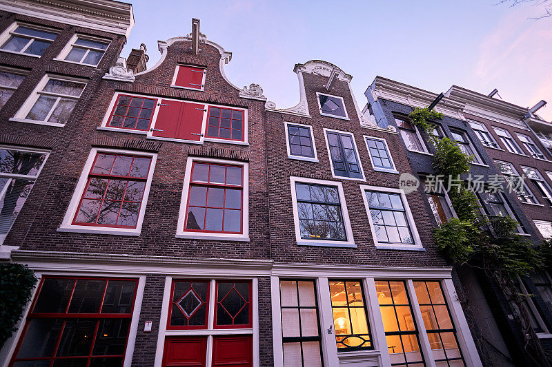 黄昏时分，阿姆斯特丹历史悠久的运河房屋的正面景观