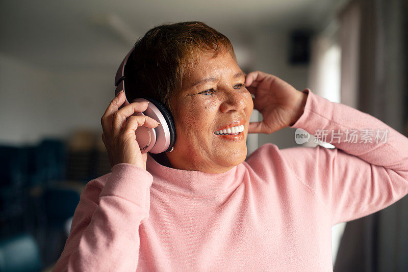 年长的女人，耳机和在家播放快乐的音乐，收音机和声音连接。老年人，播客和互联网嘻哈播放列表，娱乐和放松，在养老院唱歌