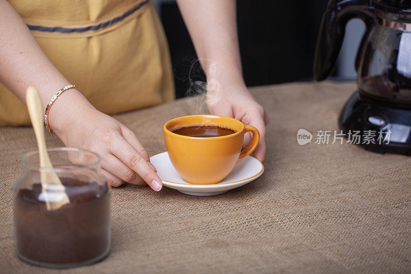 女咖啡师正在用咖啡机端上一杯新鲜咖啡
