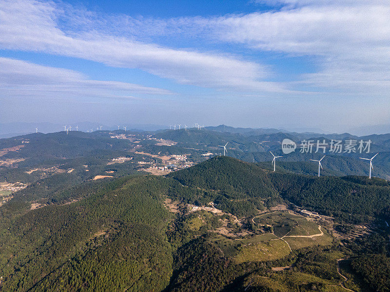 一组风力涡轮机在一个阳光明媚的山上