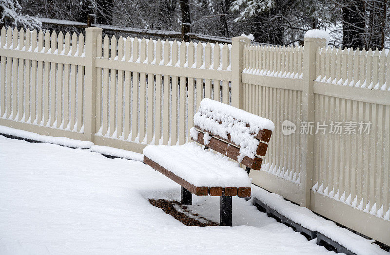 椅子和篱笆都被雪覆盖着