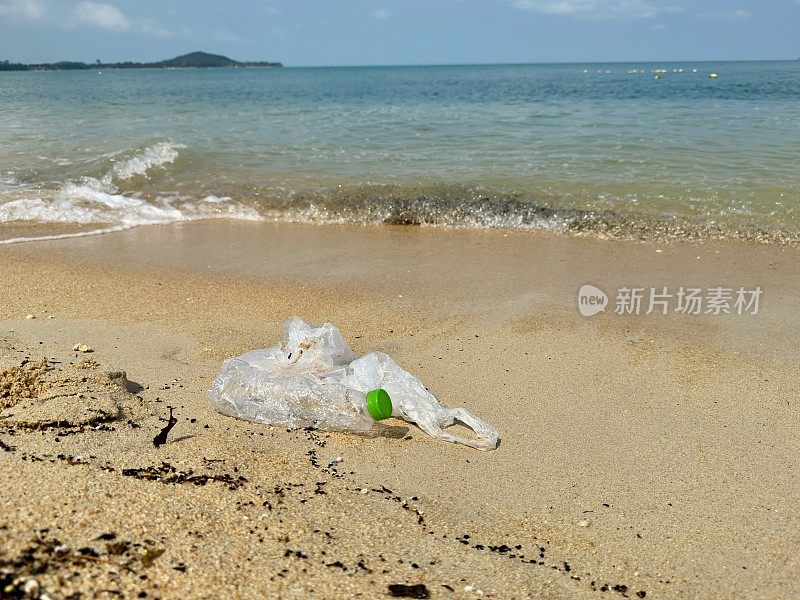 塑料袋和瓶子垃圾在海滩上