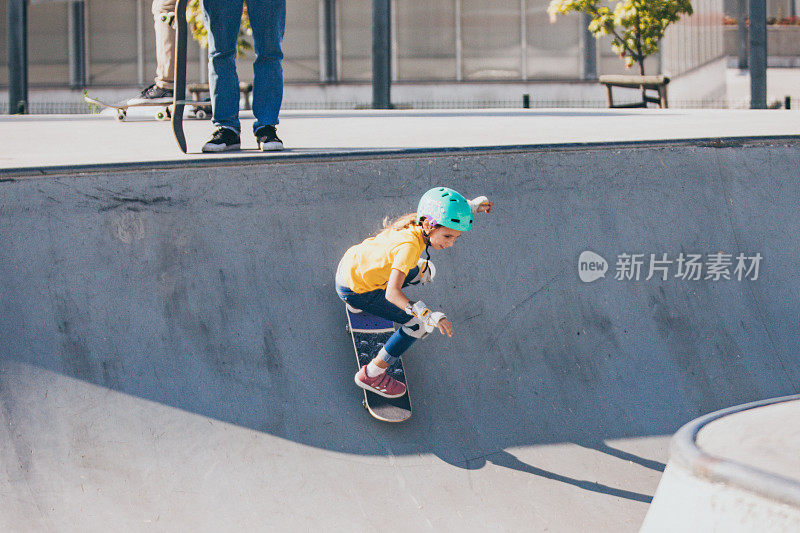 年轻的滑板女孩骑在滑板公园