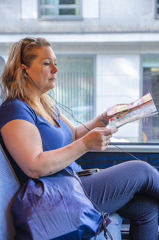 夏日波兰克拉科夫，一名女子在公交车上看杂志