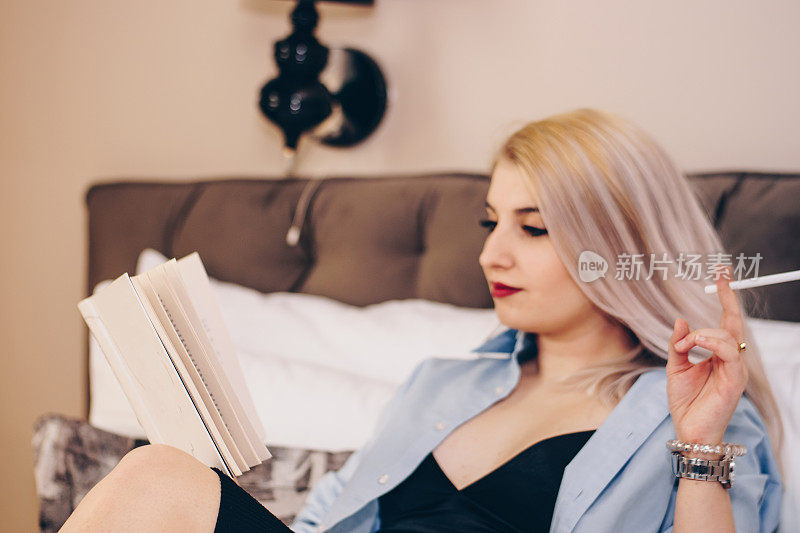 年轻女子在床上抽烟看书