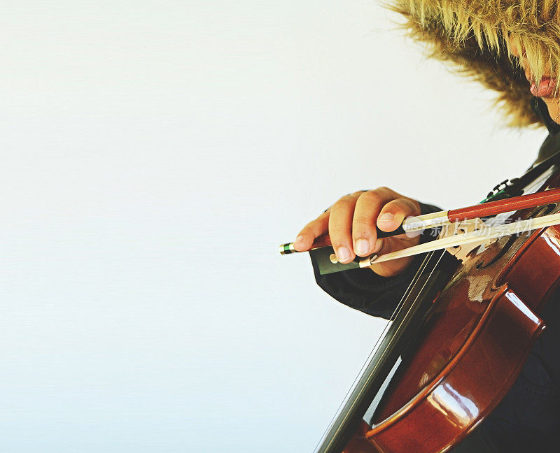 一幅水平的海报，上面是一个孩子在演奏一种弦乐器——小提琴